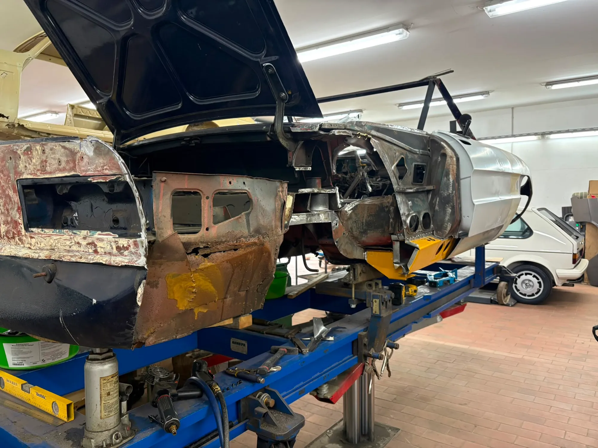 Oldtimer-Rohkarosserie während der Blecharbeiten auf der Richtbank